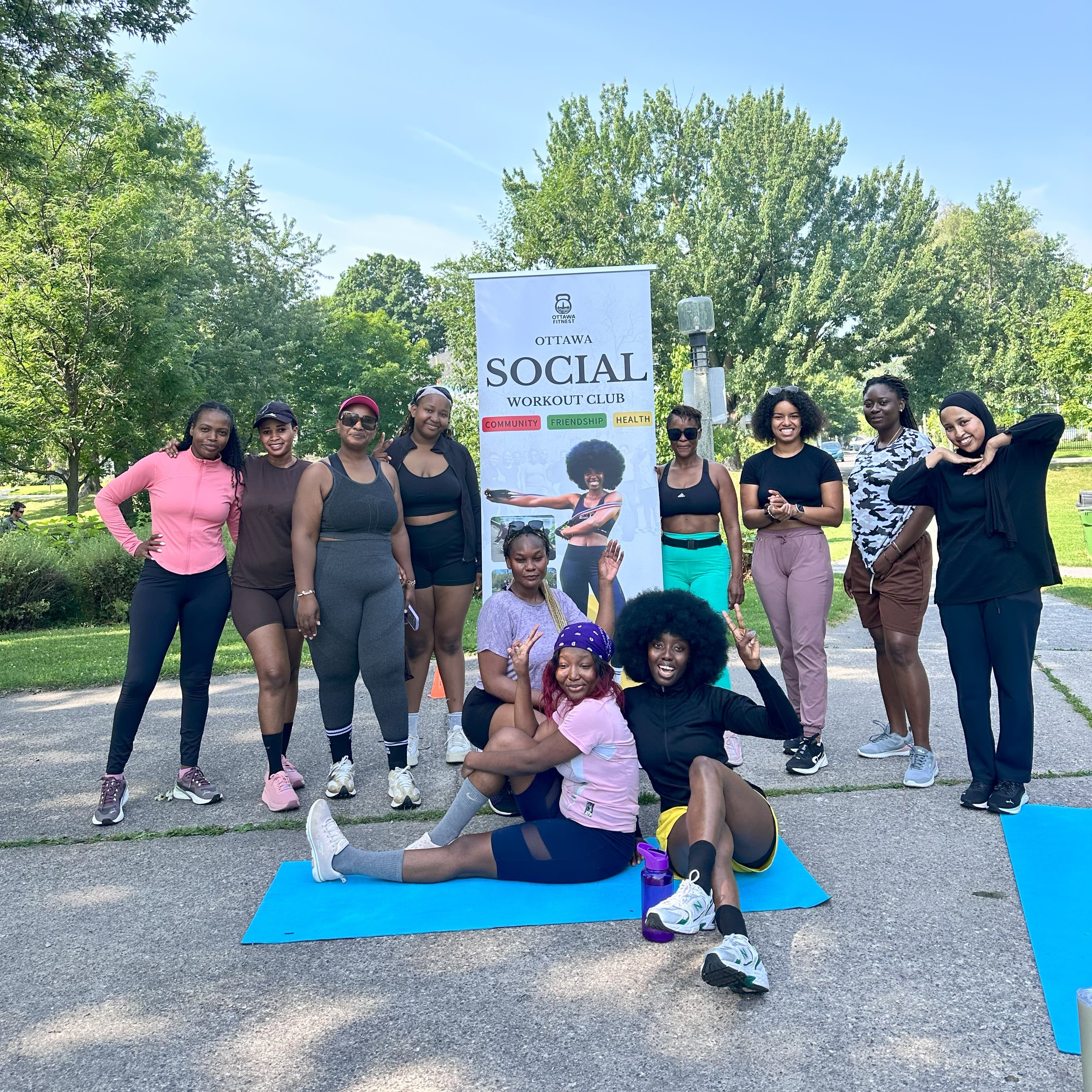 The group beside the Ottawa Social Workout Club banner at an outdoor session