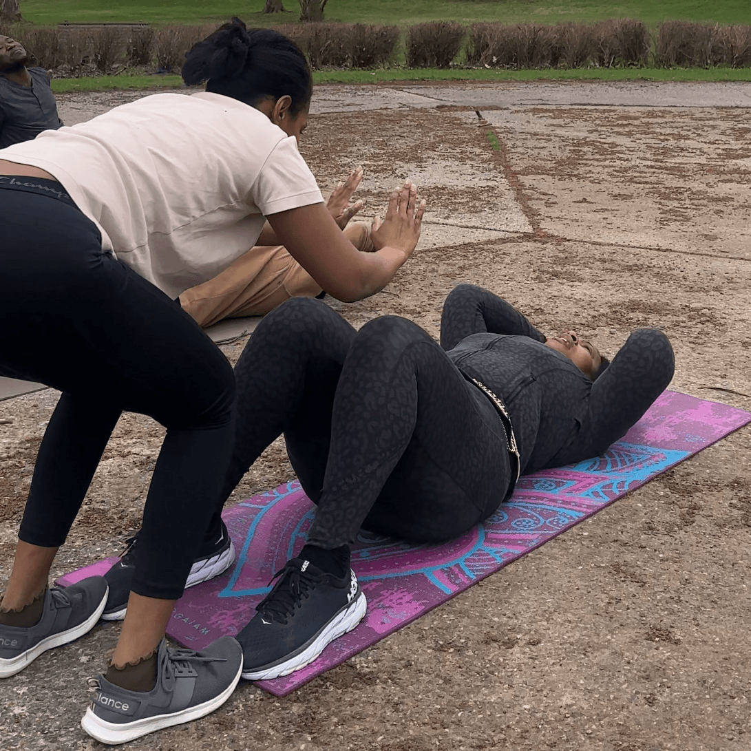 Two members working through sit-ups together on a mat at a bootcamp